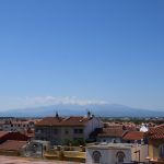 Les toits de Perpignan au premier plan et les Pyrénées au loin